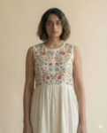 Close-up of a woman wearing a beautifully embroidered sleeveless dress. Perfect for summer or special occasions.